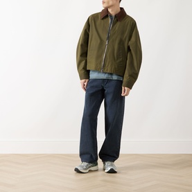 Model wearing Levis 578 Baggy Straight Leg Jeans in Time Forest, dark navy straight-cut fit, styled with olive jacket and grey trainers.