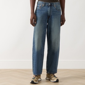 Model wearing Levi's 3049 Loose Jeans in Varnished Tarnish mid-blue wash, 100% cotton, styled with chunky trainers