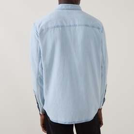 Model wearing Levi's Reg Shirt in Luisa light wash denim, rear view showing yoke seam detail and long sleeves.