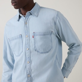 Model wearing Levi's Reg Shirt in Luisa light wash denim, featuring dual chest pockets and button-front placket.