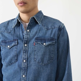Model wearing Levi's Reg Shirt in Rustic Root Hills Worn-In denim, featuring snap-button chest pockets and classic western yoke detail.