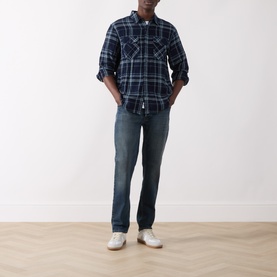 Model wearing Levi's Reg Shirt in Pier 100 Indigo plaid western check, styled with dark wash jeans and white trainers.