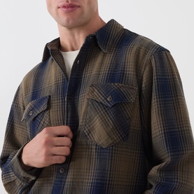 Model wearing Levi's Reg Shirt in Toby Vintage Indigo plaid check, featuring twin chest pockets and button front, styled over white crew neck tee.