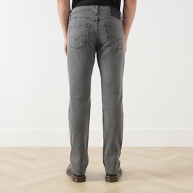 Model wearing Levi's 3049 Slim Jeans in Granite Shadow grey, rear view, styled with tan leather boots.