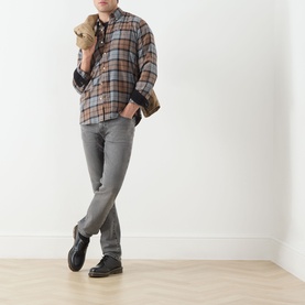 Model wearing Levis 3049 Slim Jeans in Granite Shadow with brown plaid shirt and black shoes