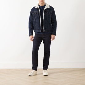 Model wearing Levis 511&trade; Slim Leg Jeans in dark blue with a sherpa-collar denim jacket and white trainers.