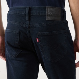 Model wearing Levi's 511&trade; Slim Leg Jeans in Why So Blue, showing rear view with logo patch, arcuate stitching and dark wash finish.