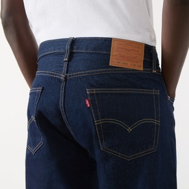 Model wearing Levi's 3049 straight jeans in Keep It Forever Rinse dark indigo denim, with tan leather patch and contrast stitching.
