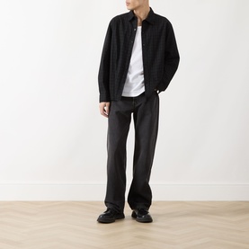 Model wearing Levi's 3049 Straight Jeans in Big Wheels dark wash, styled with a black overshirt, white tee and black loafers.