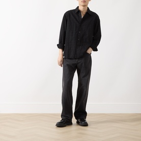 Model wearing Levi's Big Wheels straight jeans in dark grey, styled with a black long-sleeve shirt and black loafers.