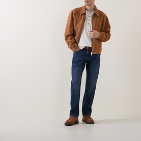 Model wearing Levi's 3049 Straight Jeans in Terra Linda dark indigo wash, styled with a tan suede jacket and white polo shirt.
