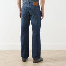 Model wearing Levi's 3049 Straight Jeans in Advice To You dark blue wash, shown from behind, styled with brown leather shoes.