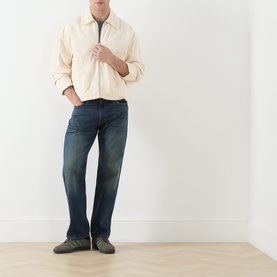 Model wearing Levi's 3049 Straight Jeans in Advice To You dark wash denim, styled with a cream zip-up jacket and grey trainers.