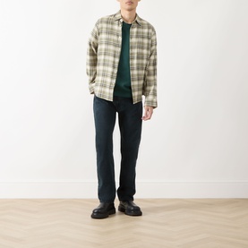 Model wearing Levi's 3049 Straight Jeans in City Boy Blues, styled with a green check overshirt and black leather shoes.