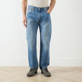 Model wearing Levi's 555&trade; Relaxed Straight Leg Jeans in Indigo Champion, mid-rise straight cut with five-pocket design, styled with grey trainers.