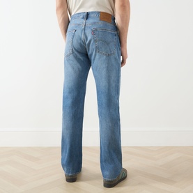 Model wearing Levi's 555 Relaxed Straight Leg Jeans in Indigo Champion, rear view showing logo patch, contrast stitching and straight-cut leg.
