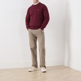 Model wearing Levi's 3049 Straight Jeans in Salty Capers, styled with a burgundy crew-neck sweatshirt and white trainers.