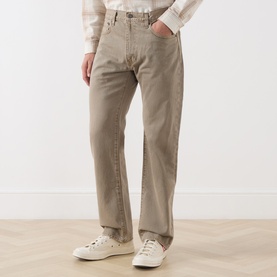 Model wearing Levi's 3049 Straight Jeans in Salty Capers, styled with white low-top trainers and a check shirt.