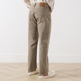 Model wearing Levi's straight jeans in Salty Capers, rear view, 100% cotton, styled with white canvas trainers