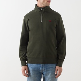 Model wearing Levis Original Housemark Logo Half-Zip Sweater in dark green with raised collar and chest logo, styled with blue jeans.