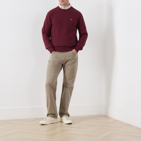 Model wearing Levi's Tawny Port cotton crew neck sweatshirt with beige chinos and white trainers.