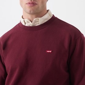 Model wearing Levi's tawny port cotton crew neck sweatshirt with small logo, styled over a checked shirt.