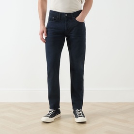 Model wearing Levi's 3049 Tapered Jeans in Why So Blue, styled with a white tee and black high-top trainers.