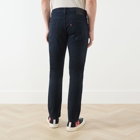 Model wearing Levi's 3049 Tapered Jeans in Why So Blue, rear view showing slim tapered fit and classic five-pocket styling.