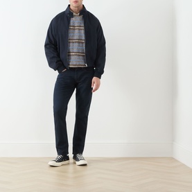 Model wearing Levis 3049 Tapered Jeans in Why So Blue, styled with a navy bomber jacket, striped polo and black canvas trainers.
