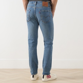 Model wearing Levi's 502&trade; Tapered Leg Jeans in Its Been A While Selvedge, mid-rise, faded wash, rear logo patch, styled with white trainers.