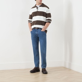 Model wearing Levis 3049 Tapered Jeans in Stonewash Stretch, styled with a brown striped polo and dark loafers.