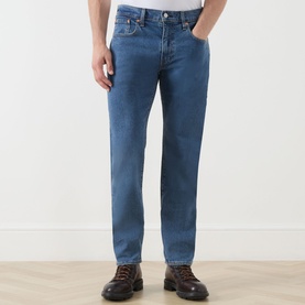 Model wearing Levi's 3049 Tapered Jeans in stonewash stretch, styled with brown leather lace-up boots.