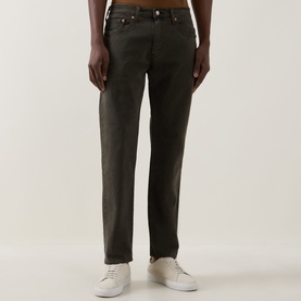 Model wearing Levis 3049 Tapered Jeans in Redwood Bough, dark olive cotton, styled with white low-top trainers.