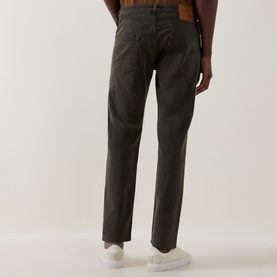 Model wearing Levi's 3049 Tapered Jeans in Redwood Bough green, rear view, styled with white trainers.