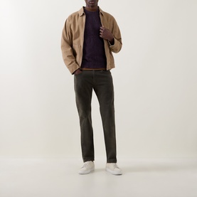 Model wearing Levis 3049 Tapered Jeans in Redwood Bough, styled with a camel overshirt, purple knit and white trainers.