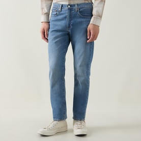 Model wearing Levi's 502&trade; Tapered Leg Jeans in Just Say Hi mid-wash blue, styled with a checked shirt and white low-top trainers.