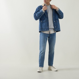 Model wearing Levis 502&trade; Tapered Leg Jeans in mid-wash blue, styled with a denim jacket, grey top and white trainers.