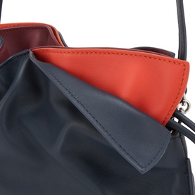 Loewe Clutch in Multicolour Deep Navy calfskin, close-up showing navy exterior with contrast orange and burgundy interior lining, silver hardware
