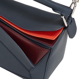 Loewe Puzzle Edge Small Crossbody Bag in Multicolour Deep Navy leather, open top revealing orange interior, silver-tone hardware detail visible.
