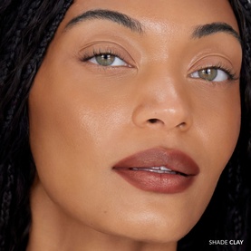 Model wearing REFY Blur Liner in shade Clay, shown as a close-up lip look with a deep terracotta-brown finish.