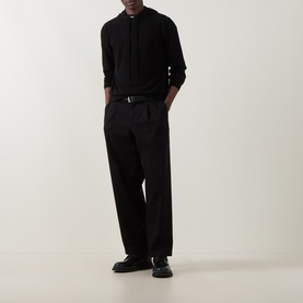 Model wearing Seven Jeans Hooded Cashmere Sweater in Coal with black wide-leg trousers and black leather shoes.