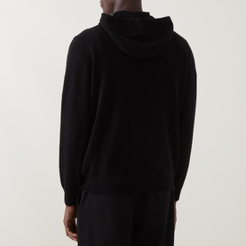 Model wearing Seven Jeans Hooded Cashmere Sweater in coal, rear view showing drawstring hood and long sleeves, styled with matching trousers.