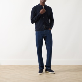 Model wearing Seven Jeans Cashmere Knitted Polo Shirt in Midnight, styled with dark blue jeans and navy trainers.