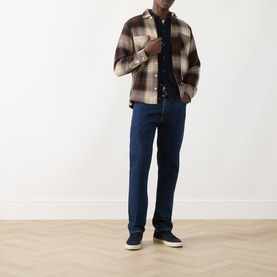 Model wearing Seven Jeans Cashmere Knitted Polo Shirt in Midnight, styled with brown check overshirt and dark blue jeans.