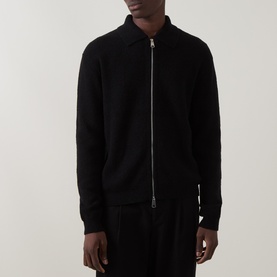Model wearing Seven Jeans Polo Collar Zip Sweater in black, with zip fastening, polo collar, and long sleeves, styled with black trousers.