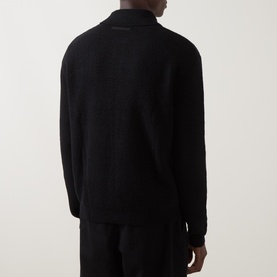 Model wearing Seven Jeans Polo Collar Zip Sweater in black, shown from rear, with polo collar, long sleeves and straight hemline.