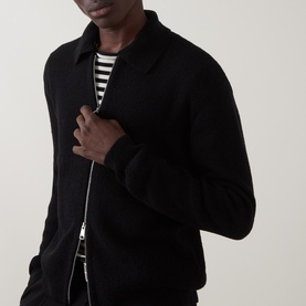 Model wearing Seven Jeans Polo Collar Zip Sweater in black with stripe crew-neck top underneath