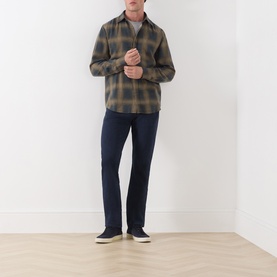 Model wearing Seven Jeans Cottage check reg shirt in olive tones, styled with navy jeans and dark trainers