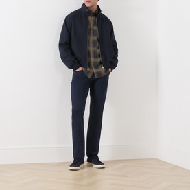 Model wearing Seven Jeans Cottage Reg Shirt in olive plaid, styled with navy bomber jacket and navy trousers.