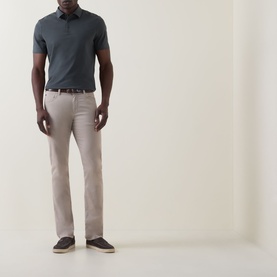 Model wearing Boggi Milano dark green cotton polo shirt, styled with stone chinos and dark brown loafers.